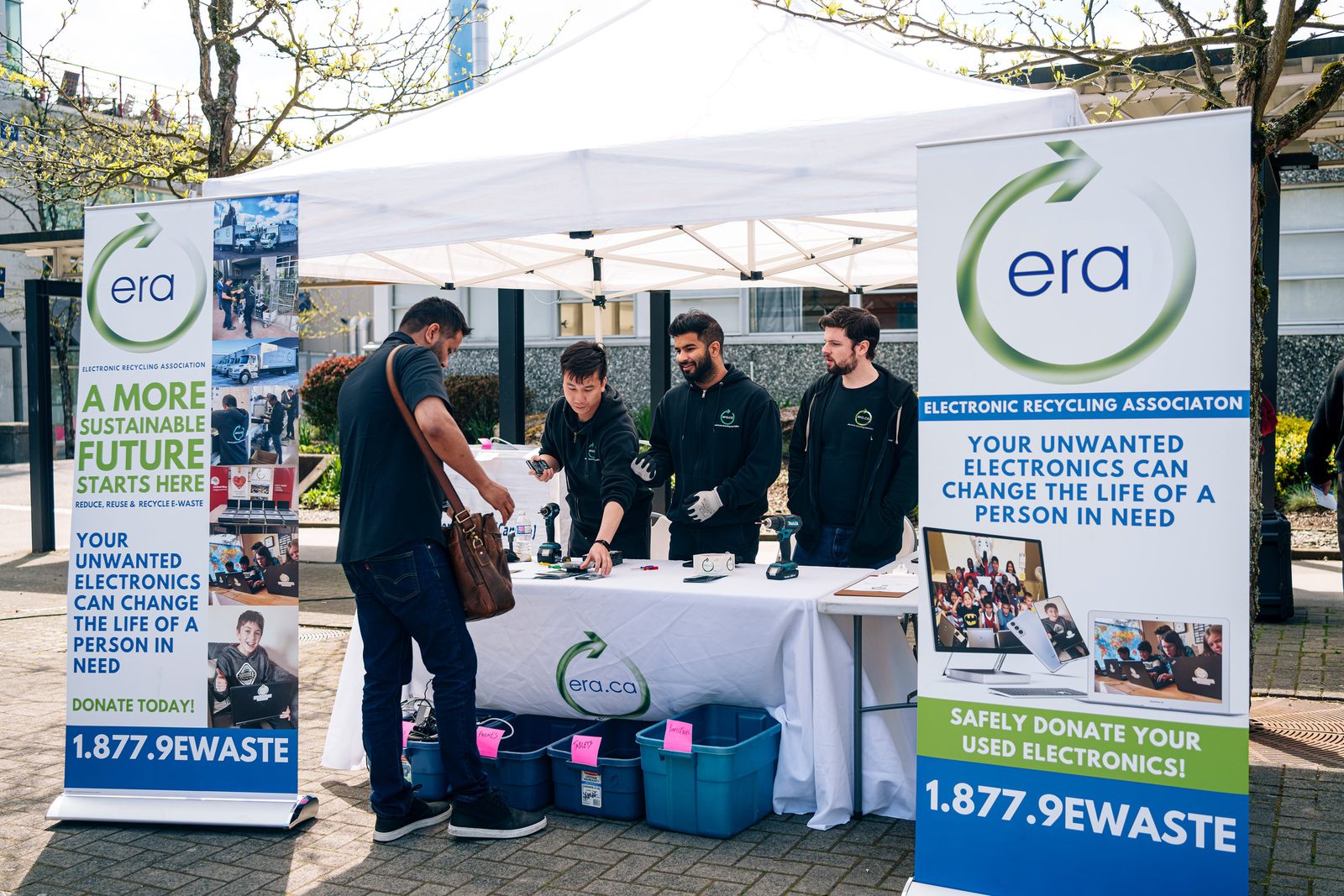 A student receiving a refurbished laptop from ERA at a community event